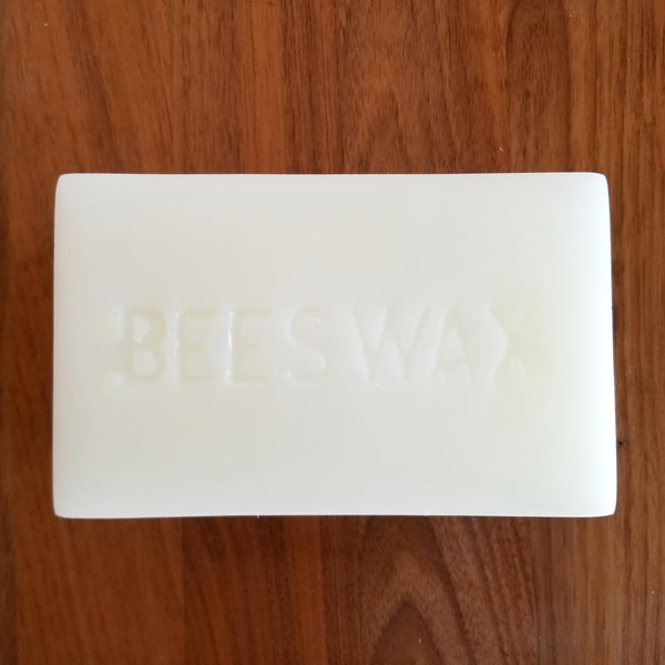 Block of white beeswax stamped with the word BEESWAX